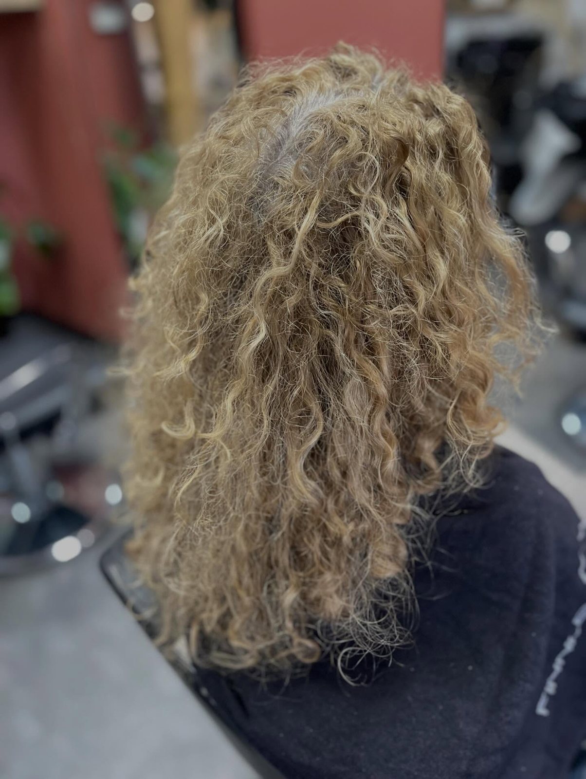 Losse blonde krullen van achteren, net gestyled