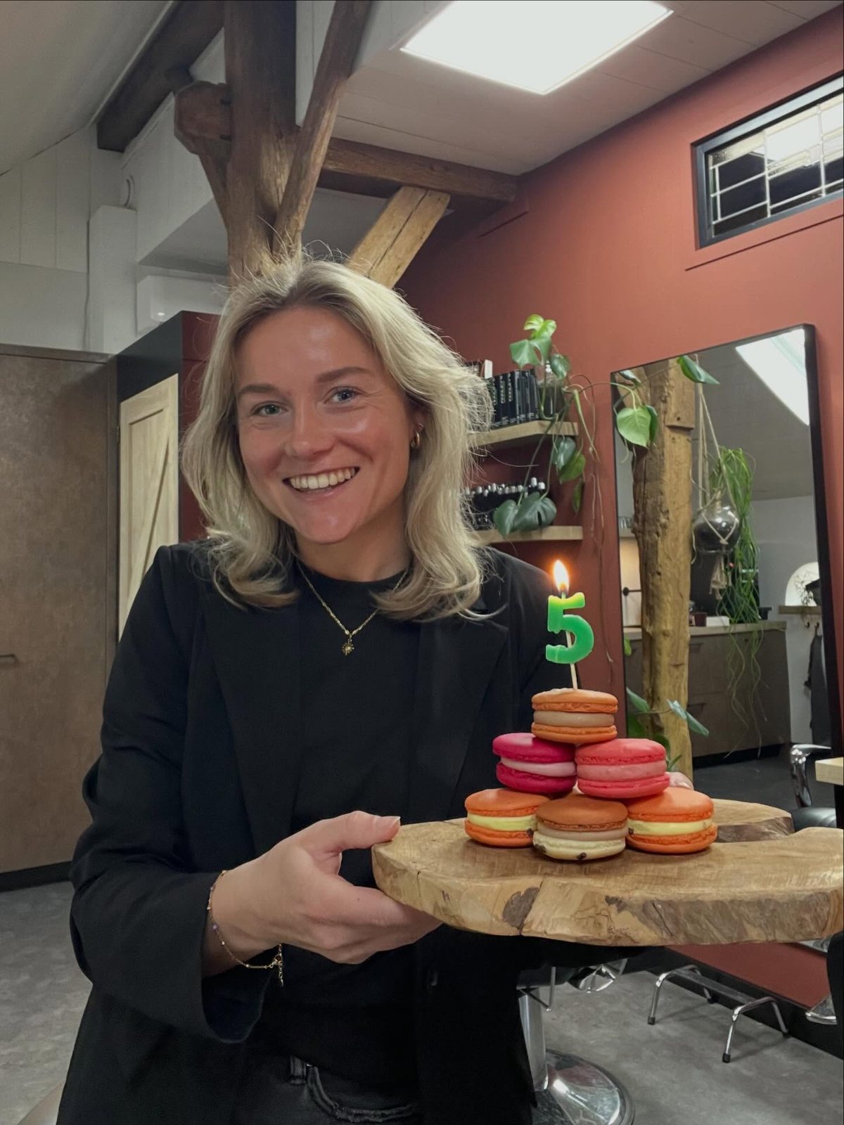 Natasja in de salon met een plank macarons en een kaarsje in de vorm van een 5